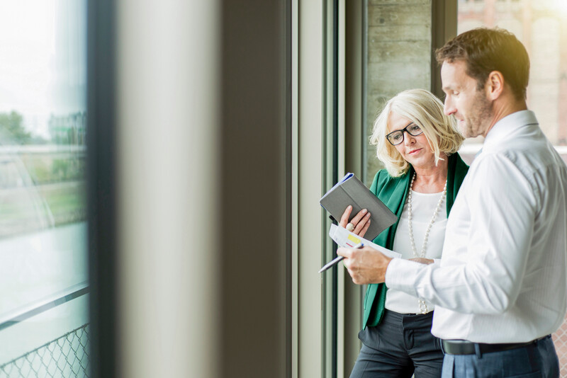 Senior colleagues standing and reviewing figures