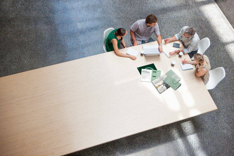 Top view of team collaboration on long meeting table